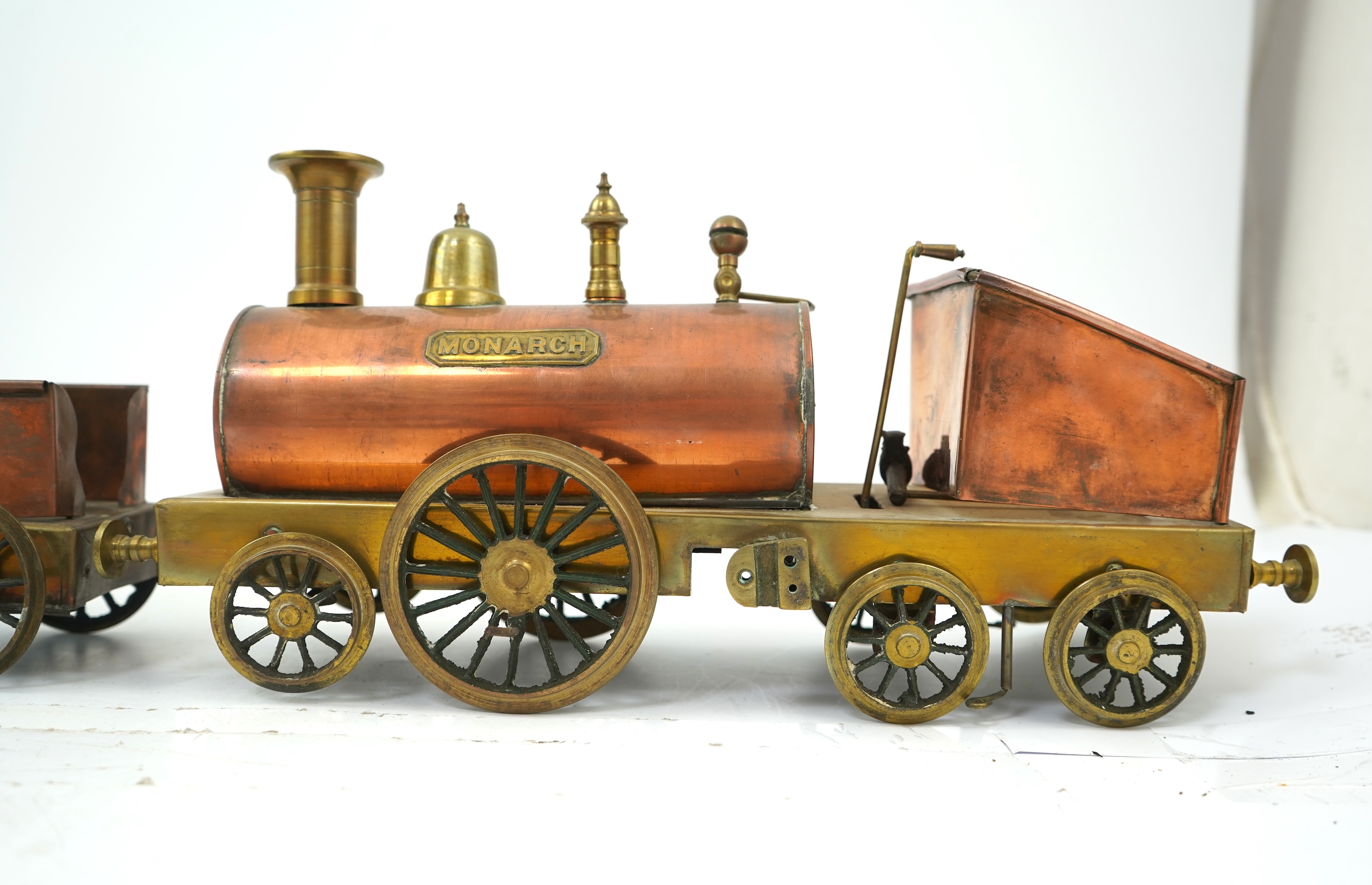 Three late 19th or early 20th century brass and copper live steam locomotives; a 2-2-4, ‘Monarch’, gauged to run on approximately 4 1/2 inch track, 33cm long frames, a 2-2-2, ‘Dragon’, gauged to run on approximately 3 1/